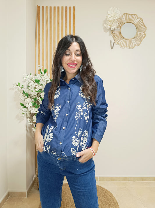 Modelo con camisa Amadea azul efecto denim y bordados florales beige.